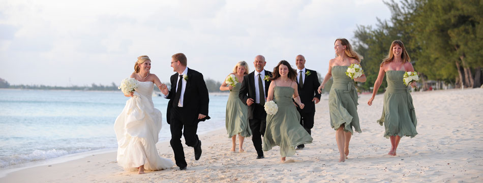 Bride Groom and Wedding Party Running on Seven Mile Beach beach wedding